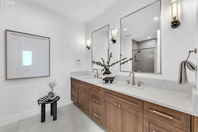 bathroom featuring tile patterned flooring, tiled shower, and vanity