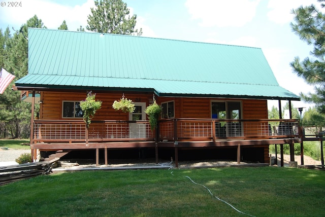 back of property featuring a wooden deck and a lawn