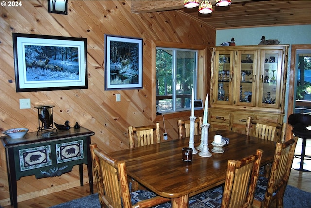 dining space with wood-type flooring and wood walls