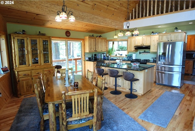 dining area featuring wood ceiling, vaulted ceiling, and light hardwood / wood-style floors