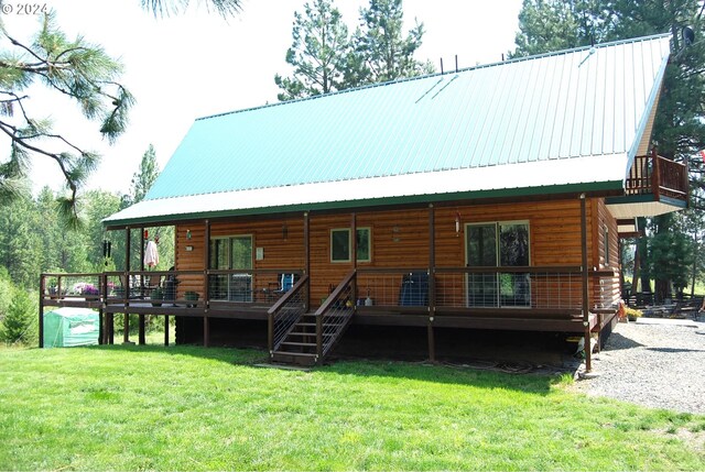 rear view of house featuring a deck and a lawn