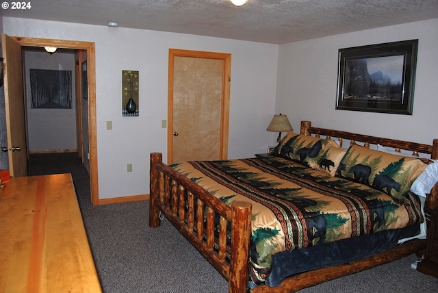 bedroom featuring a textured ceiling and dark colored carpet