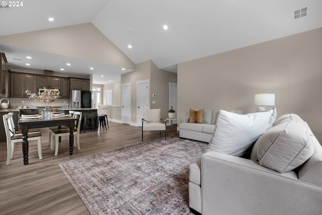 living room featuring hardwood / wood-style flooring and high vaulted ceiling