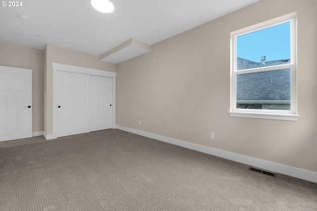 unfurnished bedroom with a closet and carpet