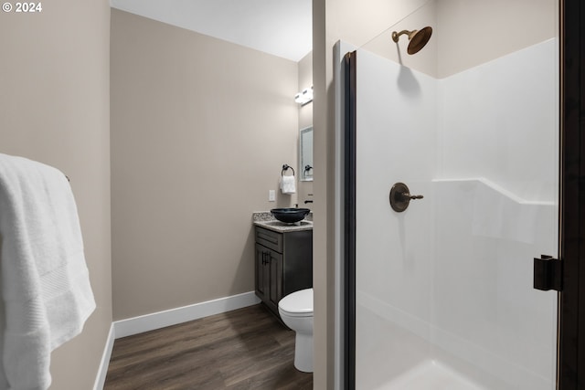 bathroom with vanity, toilet, hardwood / wood-style flooring, and walk in shower