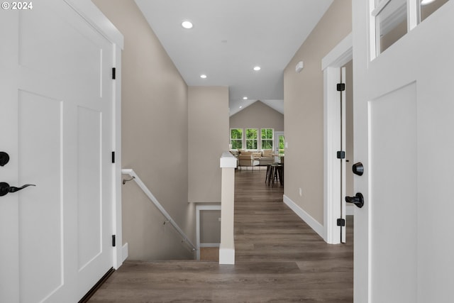 corridor with vaulted ceiling and dark hardwood / wood-style flooring