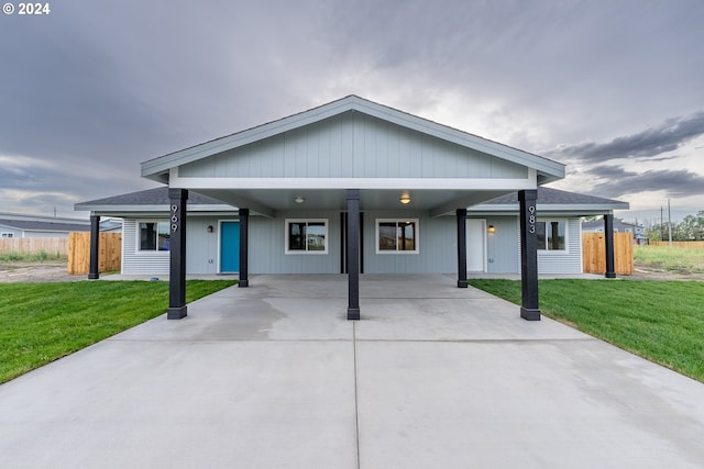 view of front of property featuring a front yard and a carport