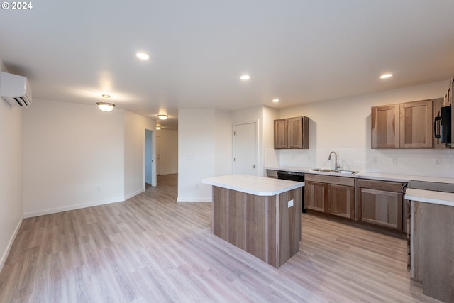 kitchen with sink, light hardwood / wood-style flooring, an AC wall unit, backsplash, and a kitchen island