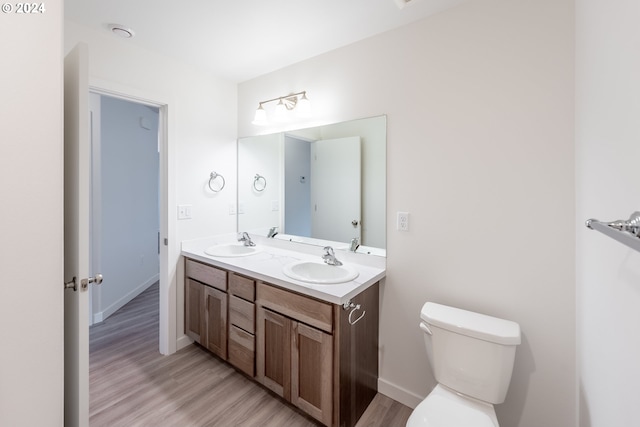 bathroom with hardwood / wood-style floors, vanity, and toilet