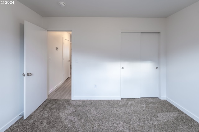 unfurnished bedroom featuring carpet flooring and a closet