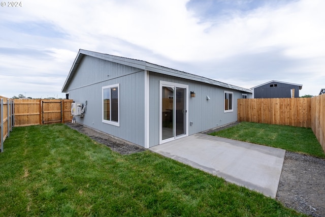 rear view of house featuring a patio area and a lawn