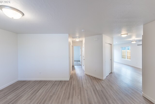 empty room featuring a textured ceiling and light hardwood / wood-style floors