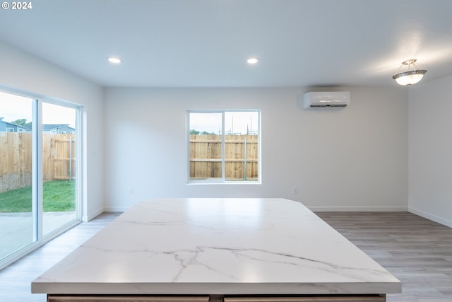 dining space featuring a wall mounted air conditioner and light wood-type flooring