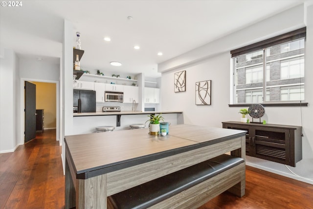 dining space featuring sink and dark hardwood / wood-style flooring