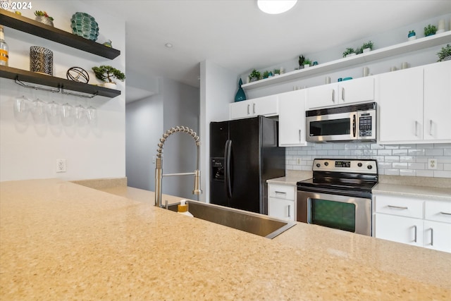 kitchen featuring decorative backsplash, stainless steel appliances, and white cabinets