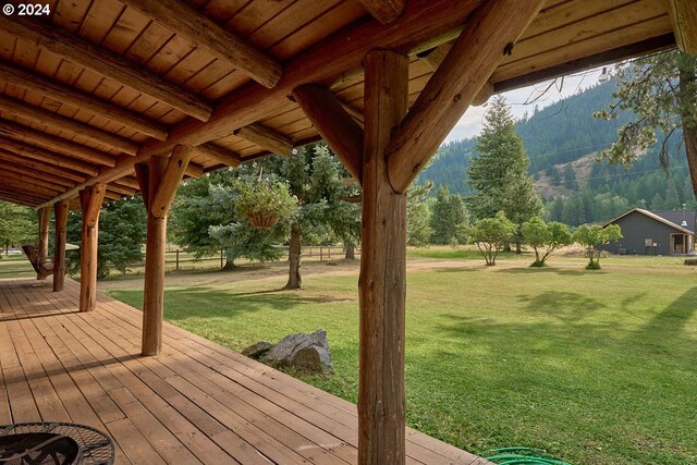 deck with a mountain view and a yard