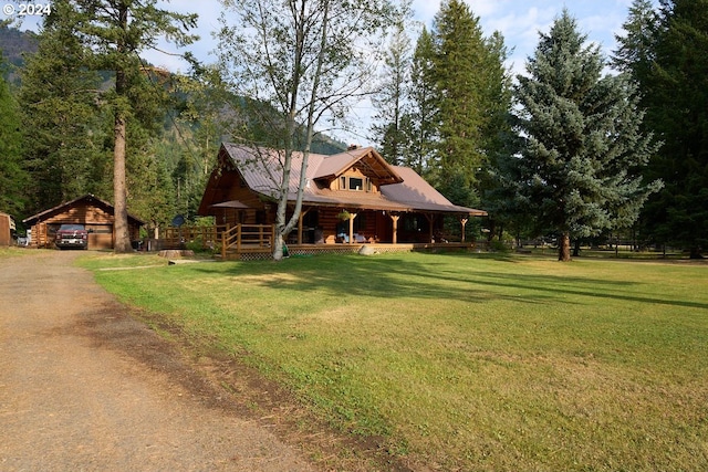 cabin with a porch, a garage, and a front yard