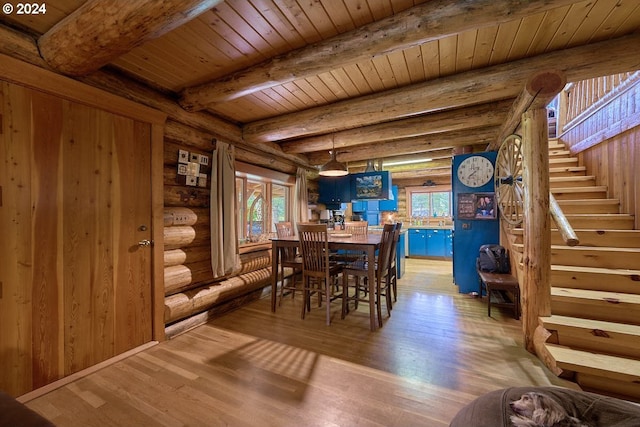 dining space with light hardwood / wood-style floors, rustic walls, and a healthy amount of sunlight