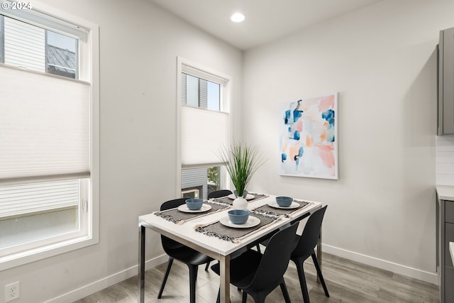 dining space featuring light wood-type flooring and plenty of natural light