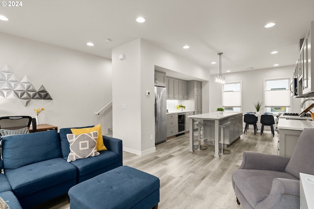 living room with light hardwood / wood-style floors and beverage cooler