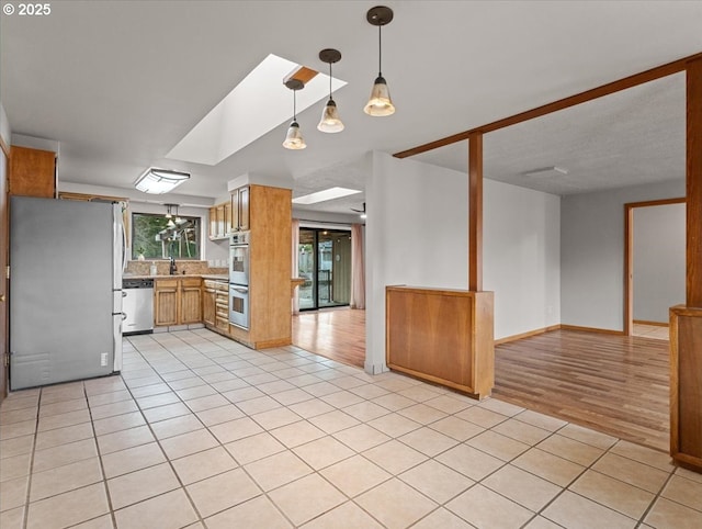 kitchen featuring light tile patterned flooring, appliances with stainless steel finishes, and sink