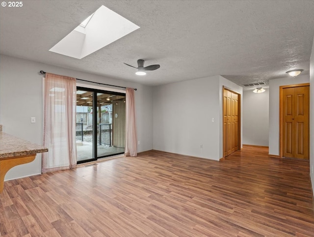 spare room with wood-type flooring, ceiling fan, and a textured ceiling