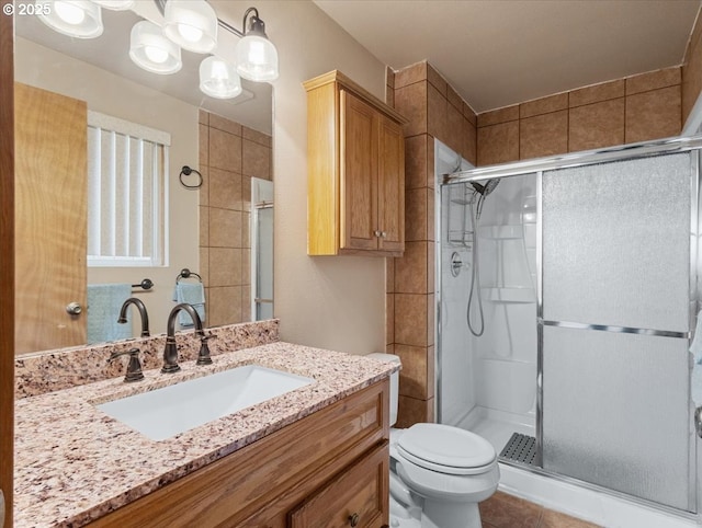 bathroom with vanity, tile patterned floors, a shower with door, and toilet