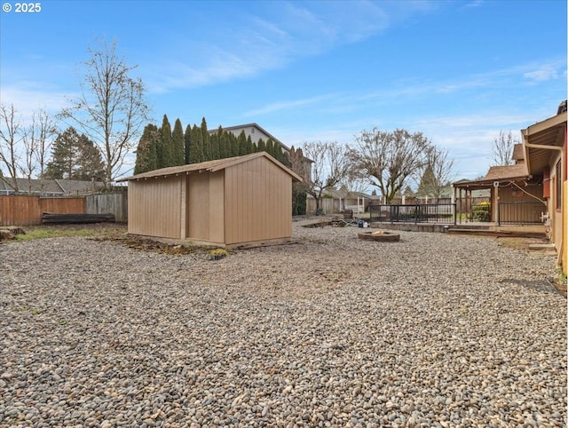 view of yard featuring a storage shed and an outdoor fire pit