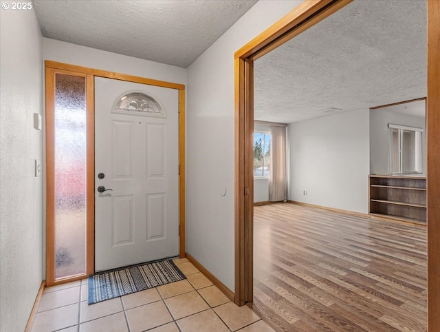 entrance foyer with a textured ceiling and light hardwood / wood-style flooring