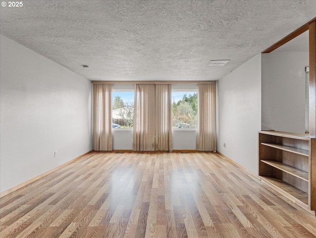 unfurnished living room featuring a textured ceiling and light wood-type flooring