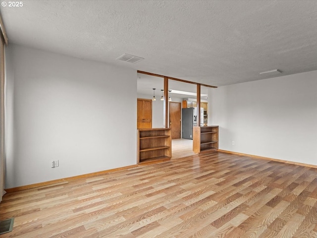 unfurnished living room featuring light hardwood / wood-style floors and a textured ceiling