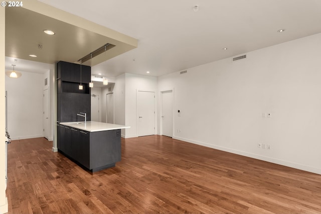 kitchen with high end refrigerator, an island with sink, and dark hardwood / wood-style floors