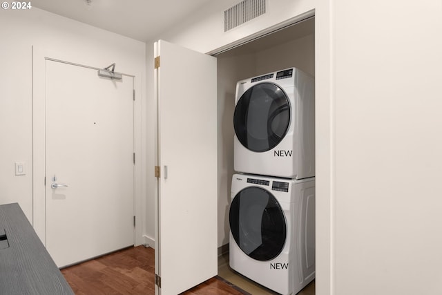 washroom featuring dark hardwood / wood-style flooring and stacked washer / drying machine