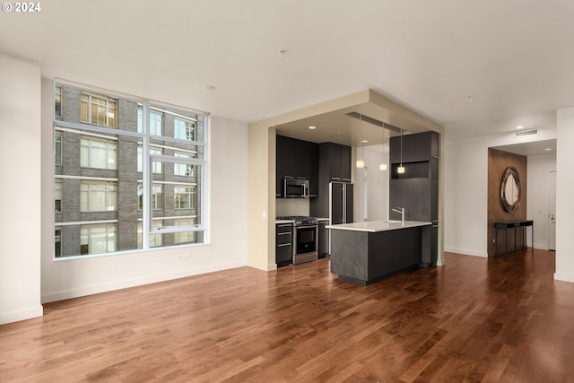 kitchen with plenty of natural light, a kitchen island, wood-type flooring, and appliances with stainless steel finishes