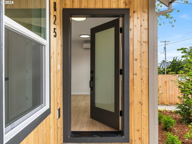 view of exterior entry with a wall mounted air conditioner