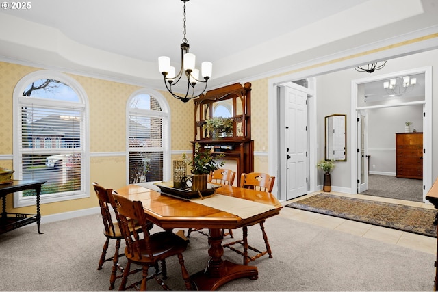 carpeted dining space featuring a notable chandelier and a tray ceiling