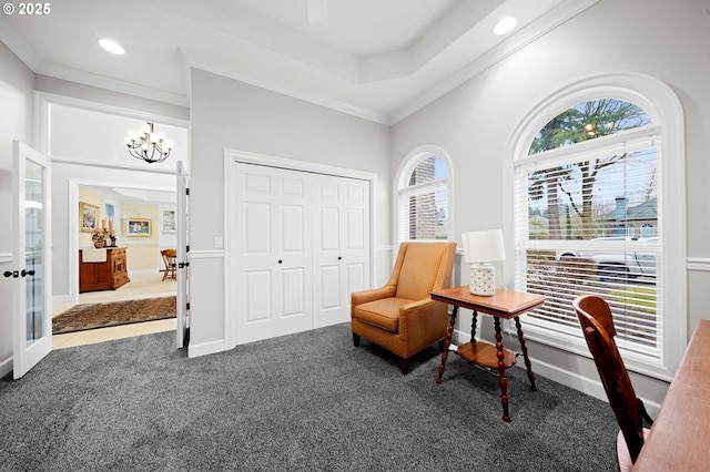 sitting room featuring crown molding, carpet flooring, a wealth of natural light, and an inviting chandelier