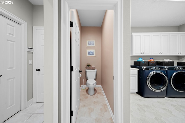 clothes washing area featuring cabinets and washing machine and dryer