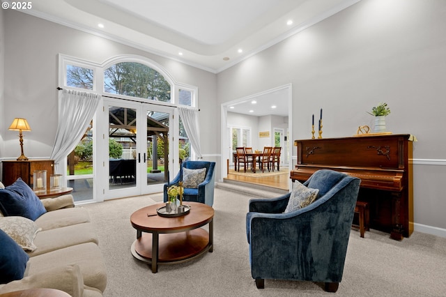 living room with a high ceiling, plenty of natural light, light colored carpet, and french doors