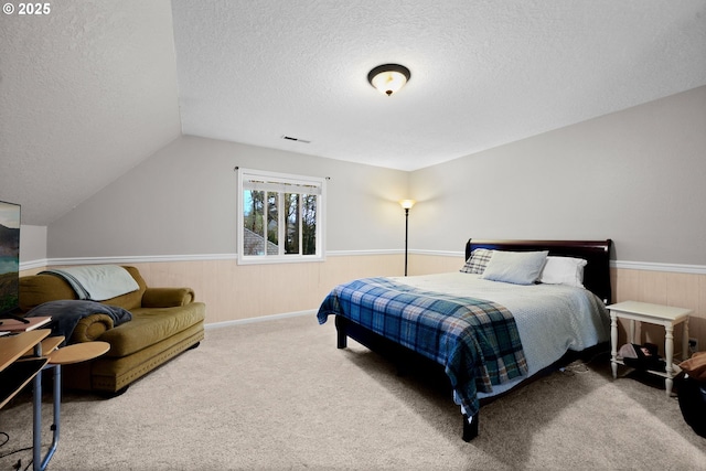 carpeted bedroom with lofted ceiling and a textured ceiling