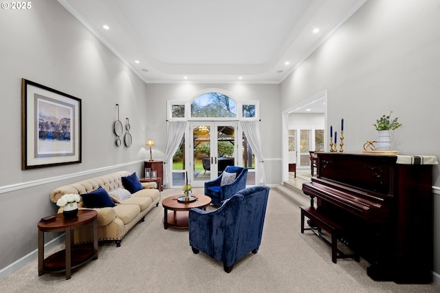 living room featuring a towering ceiling, a tray ceiling, light carpet, and french doors