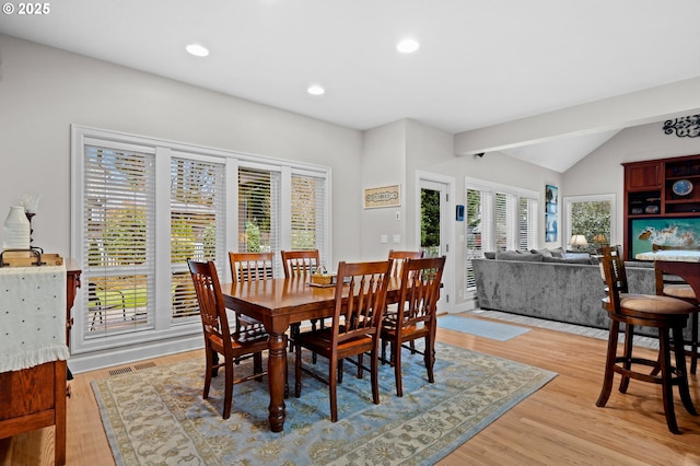 dining space with lofted ceiling and light wood-type flooring