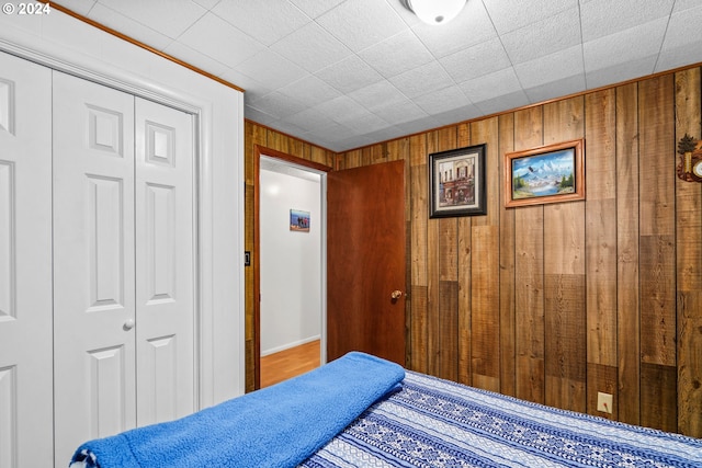 bedroom featuring a closet and wood walls