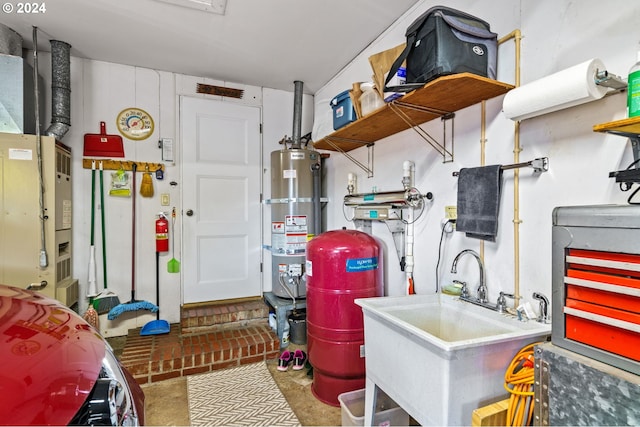 utility room featuring sink and strapped water heater