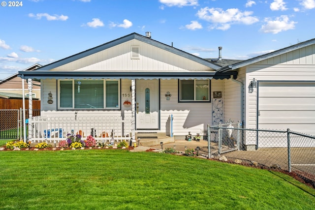 view of front of house featuring a porch, a front lawn, and a garage