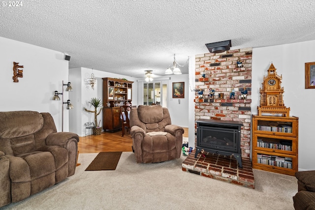 carpeted living room with a brick fireplace, a textured ceiling, and ceiling fan