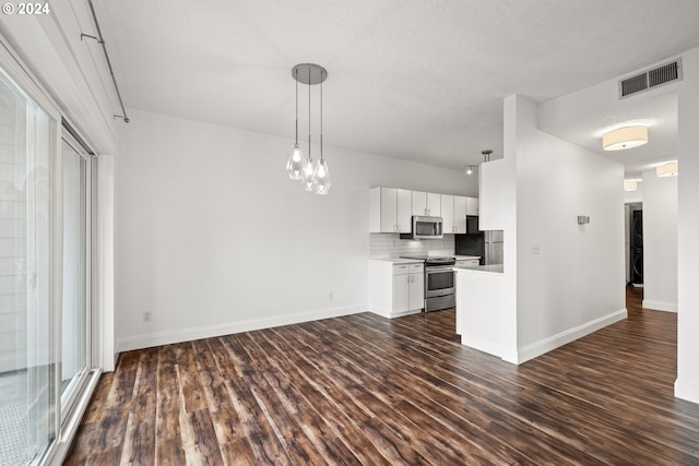 unfurnished living room with a chandelier and dark wood-type flooring