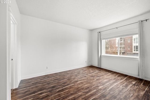 unfurnished room featuring a textured ceiling and dark wood-type flooring