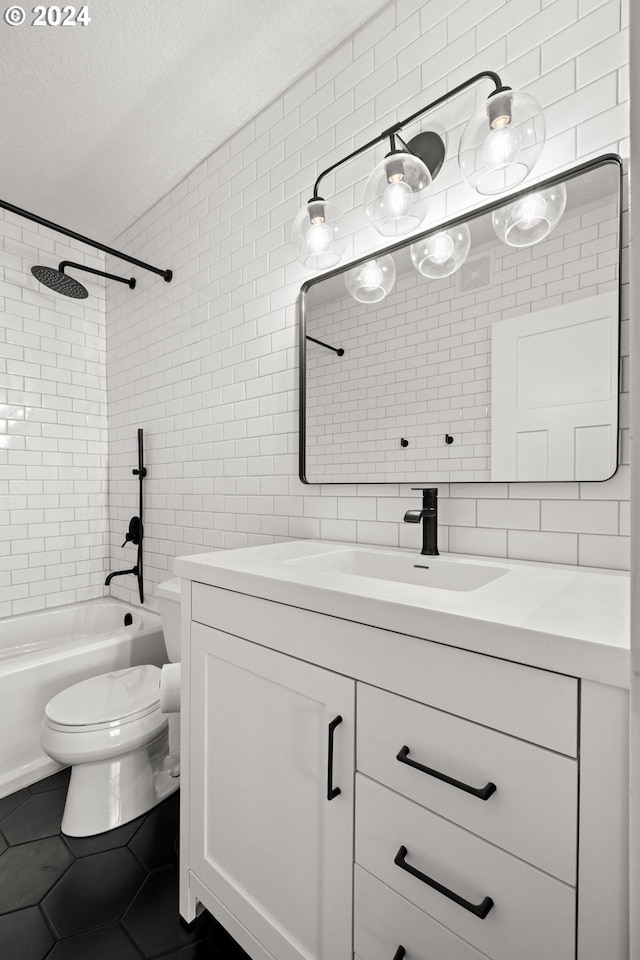 full bathroom with vanity, tile patterned flooring, tiled shower / bath combo, a textured ceiling, and tile walls