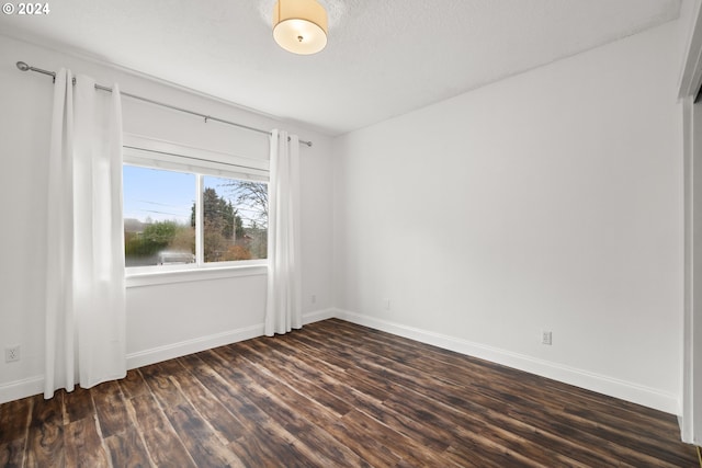 unfurnished room with dark hardwood / wood-style flooring